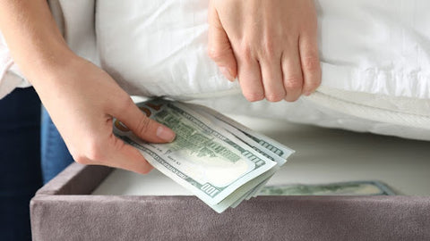 hiding stack of cash under mattress in bed