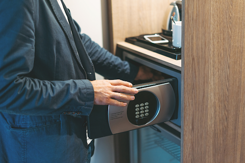 man putting object in safe