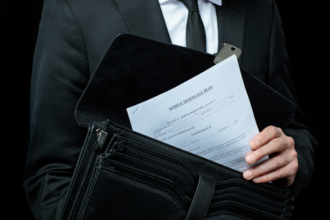 man in suit holding paper out of fireproof bag