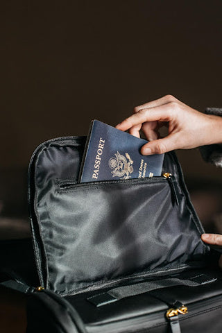 hand putting passport into fireproof bag for safety