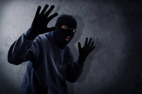 burglar with mask gloves hands up