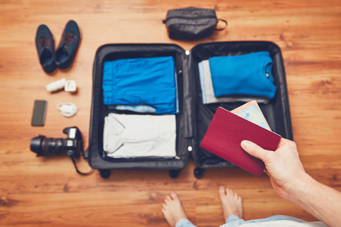 woman putting passport in suitcase