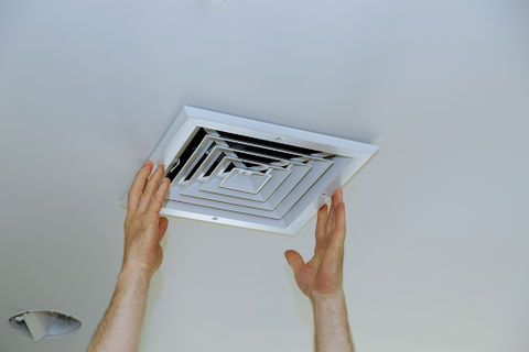 A person opening a air vent in the roof