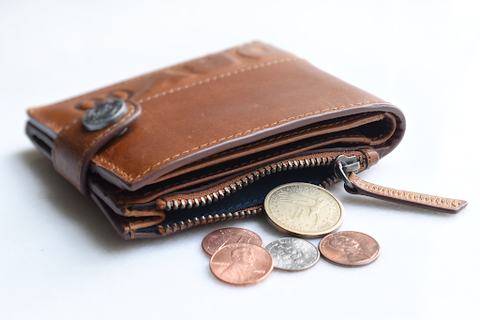 A leather wallet with some coins