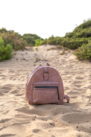 pink bag with many zips on the sand