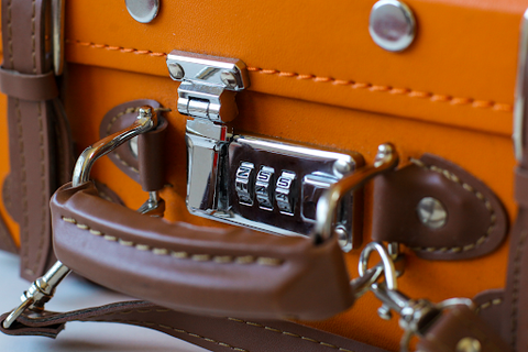 An orange suitcase with a lock combination to open and close