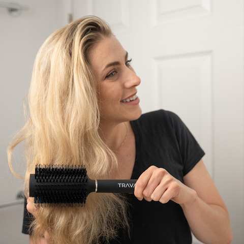 A lady brushing her hair with the Travah Diversion brush