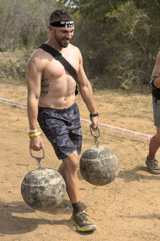 neil holding 2 weights, strong, man, spartan race, camo shorts
