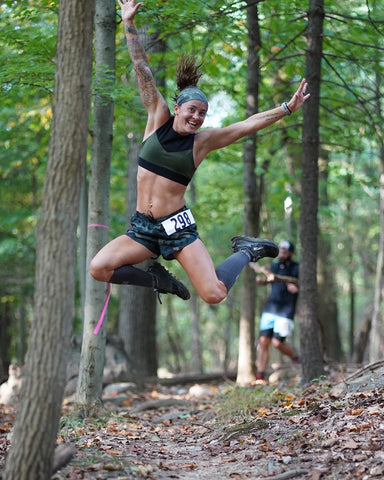 Star athlete Dixie Bonner hits a airborne pose in her gray MudGear compression socks