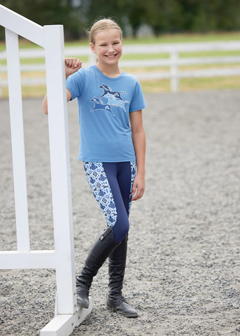 girl wearing tights and matching shirt next to a horse jump standard