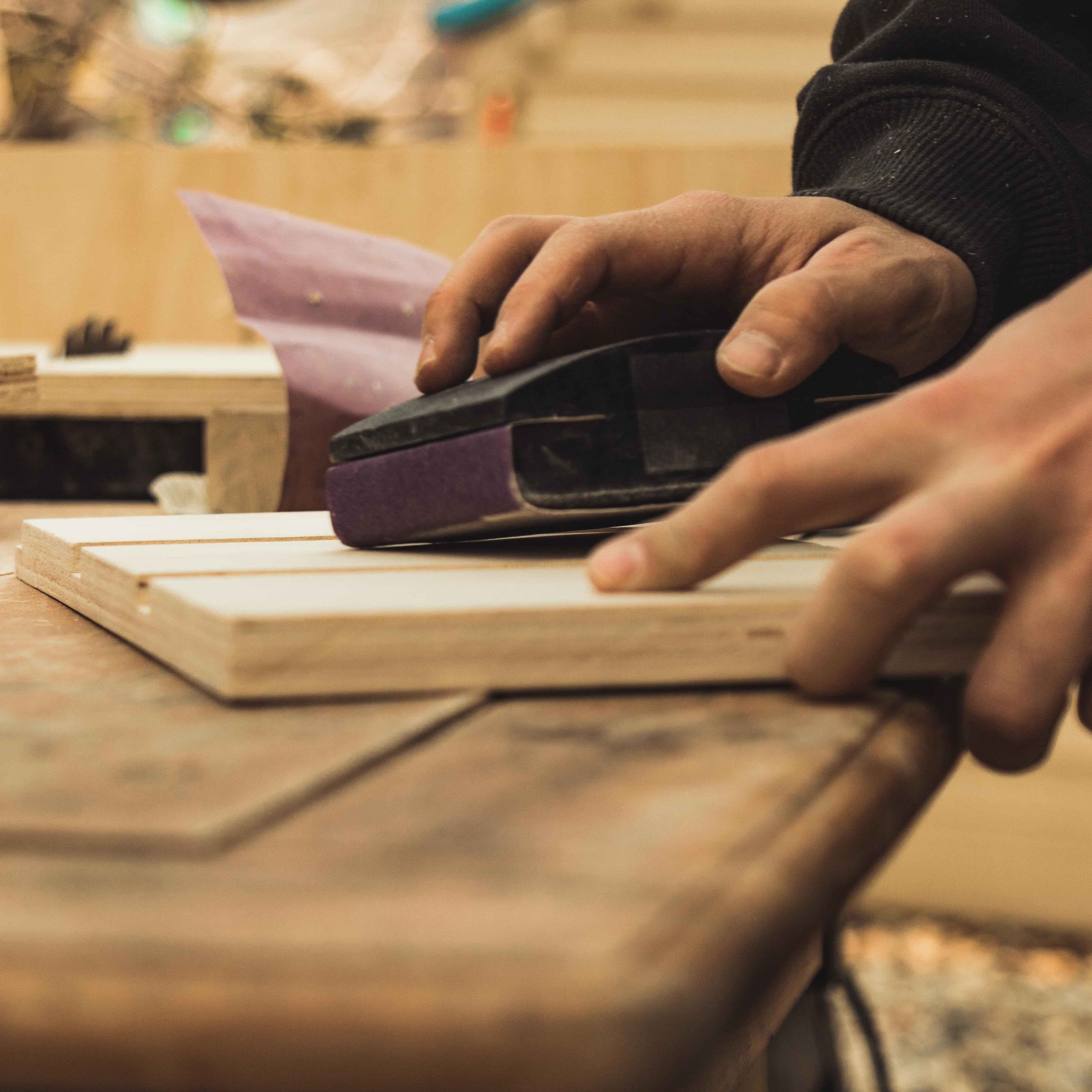 Man sanding custom made bathroom cabinets