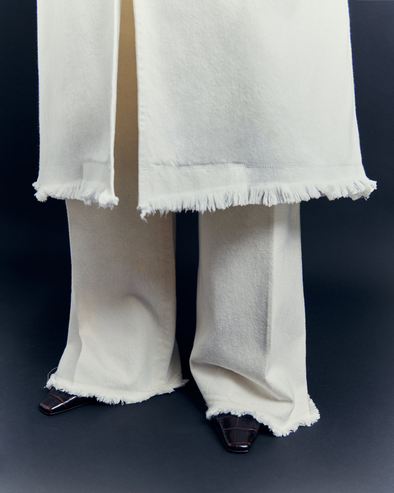 Issue Twelve white denim coat and trousers in organic cotton with frayed raw edge
