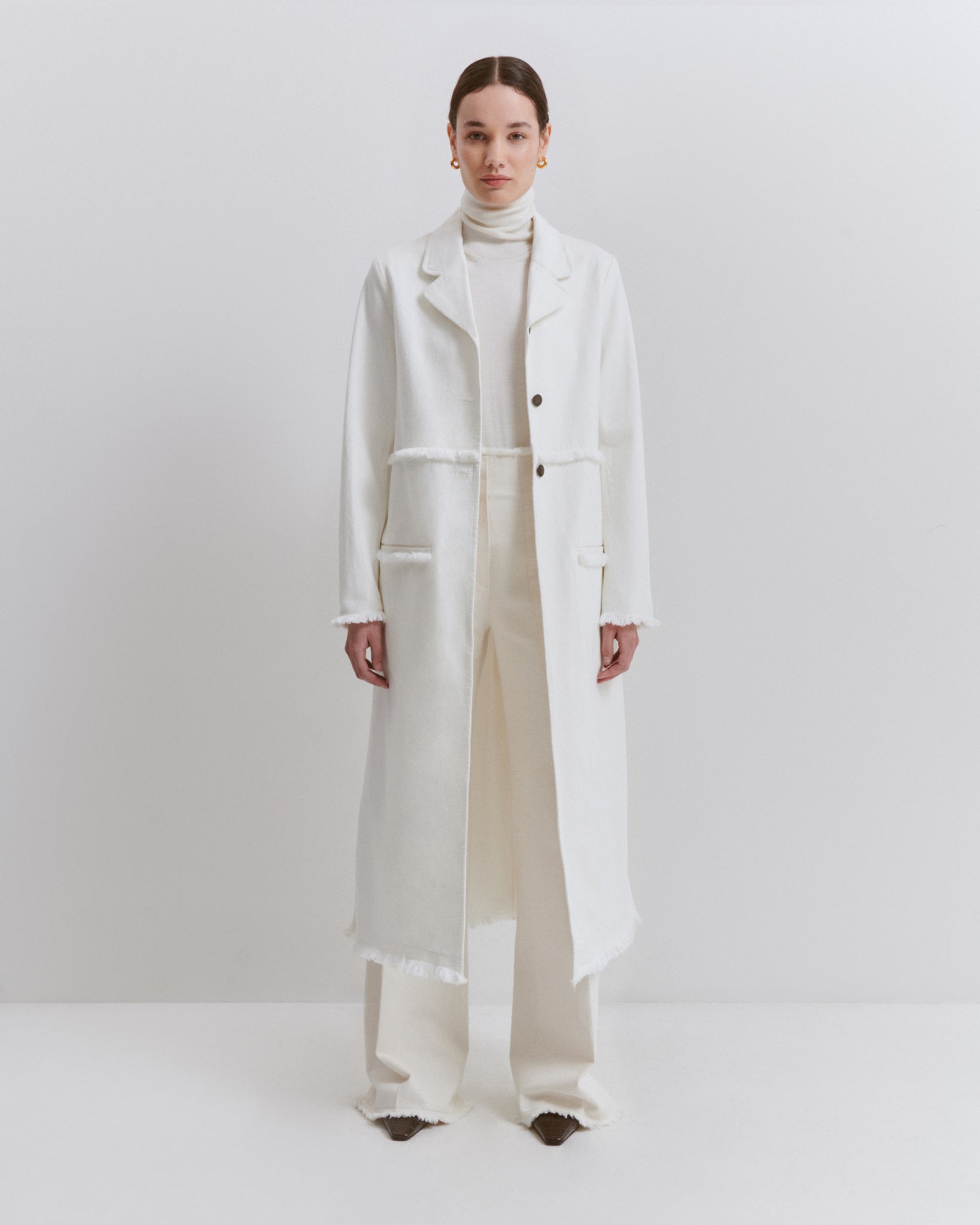 model wears Issue Twelve white denim coat in organic cotton with white denim trousers
