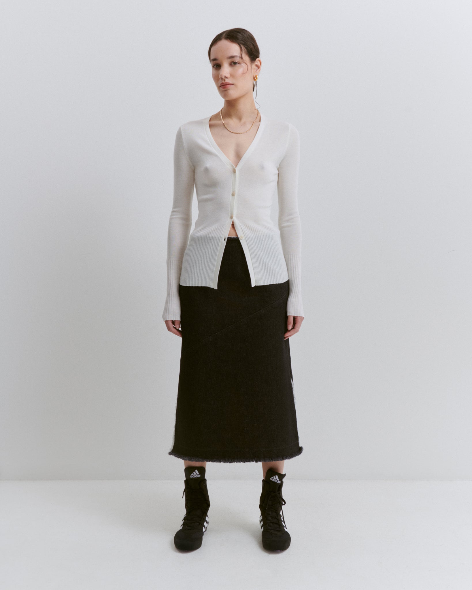 model wears Issue Twelve white wool cardigan with black organic cotton denim midi pencil skirt