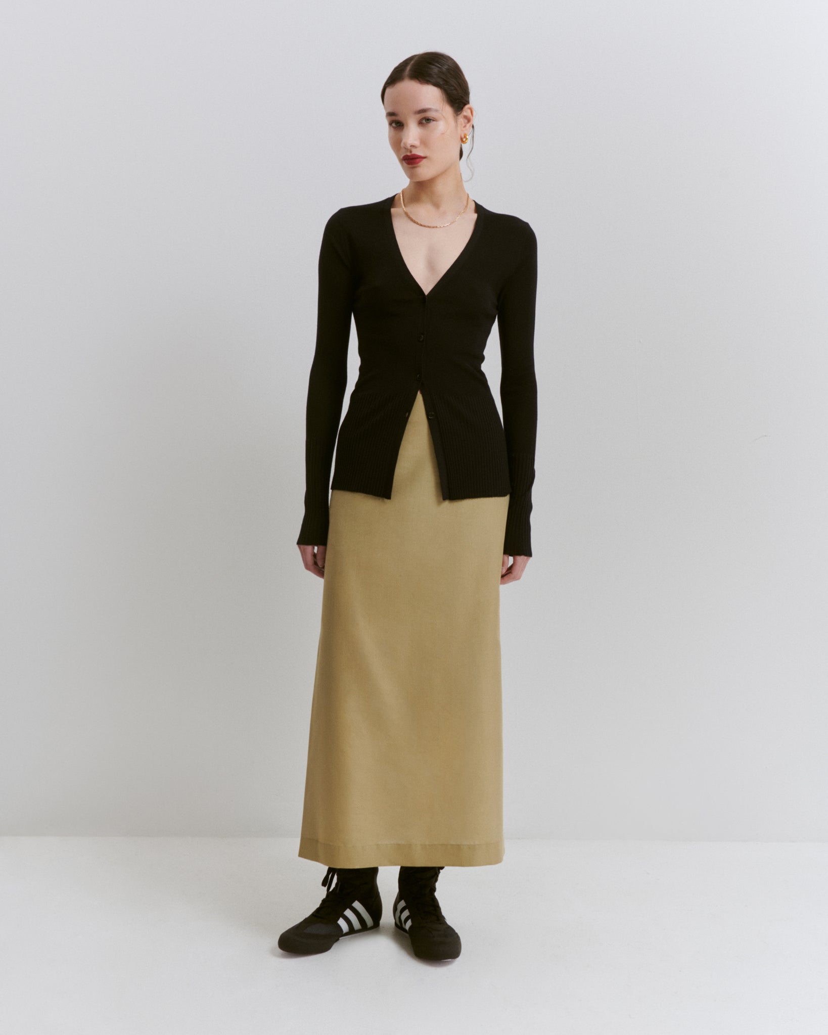 model wears Issue Twelve black cardigan and green wool silk pencil maxi skirt