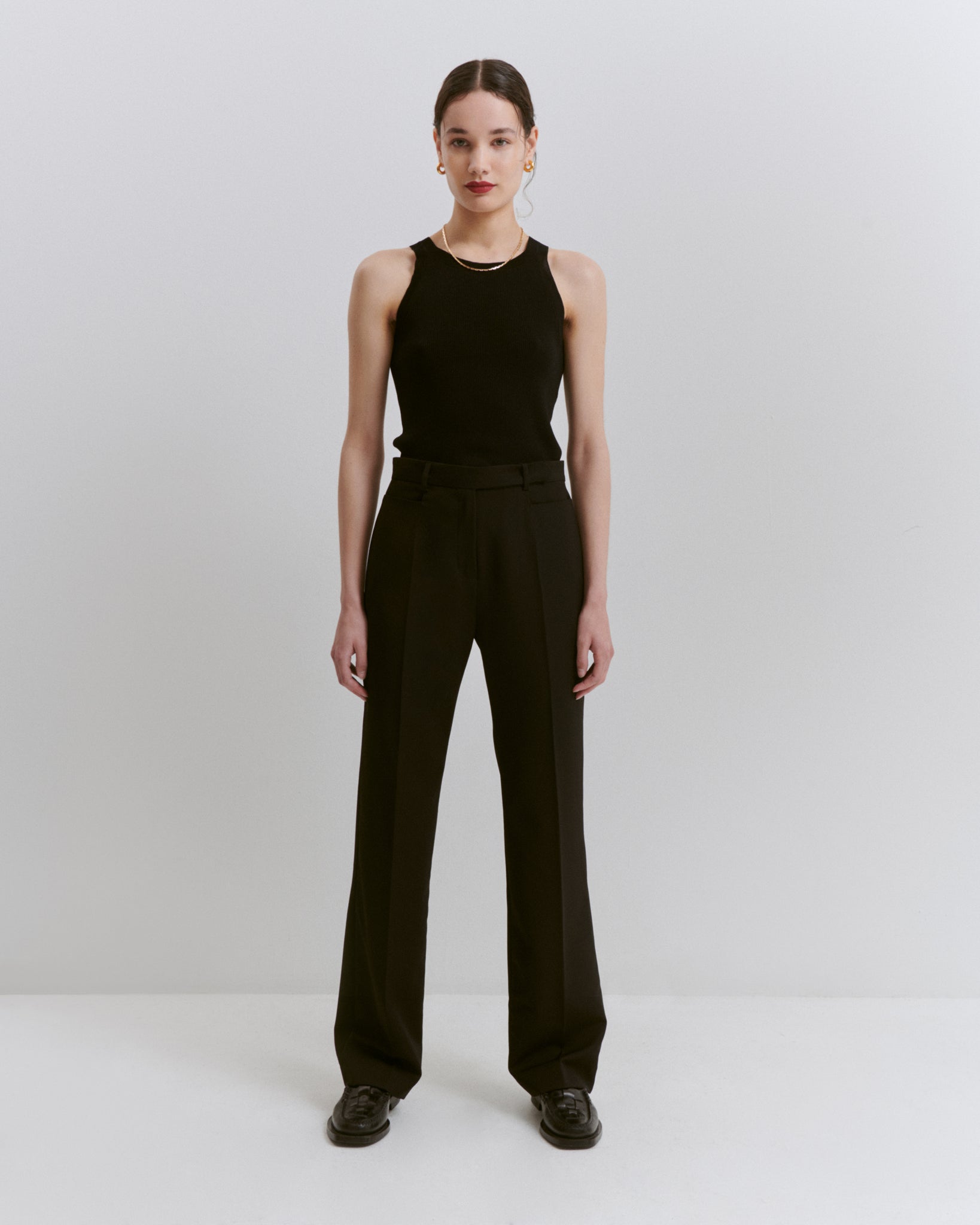 model wears Issue Twelve black wool vest and black wool straight leg trousers