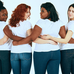 An image of four girls all wearing white t-shirts and jeans.
