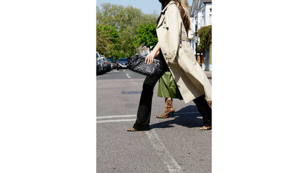 model-wears-black-flared-trousers-traditional-trench-coat