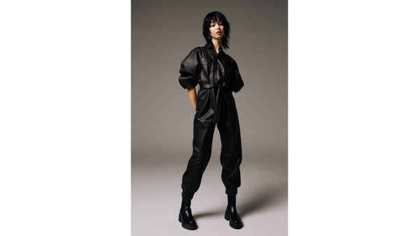 Model-wears-SKIIM-black-leather-jumpsuit-and-black-boots