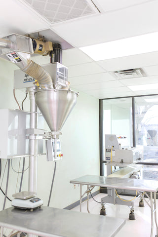 Photographic image depicting a Kratom Powder packaging machine inside of the happy hippo packaging lab. The packaging Lab is incredibly clean proving that Happy Hippo follows (GMP) Good Manufacturing Practices