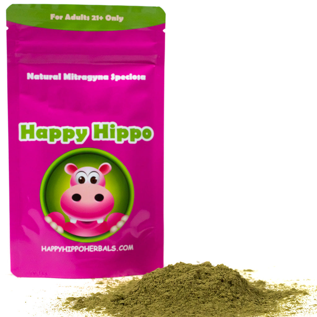 photographic image of a packet of Happy Hippo Brand Kratom Powder, sitting behind a large heap of loose Kratom Green Maeng Da Kratom Powder.