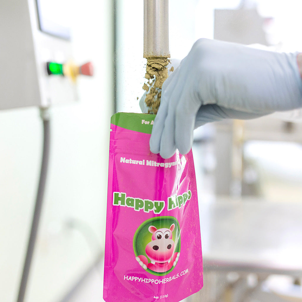 Photographic image depicting a packet of Happy Hippo Brand Kratom Powder, being filled with raw kratom powder in a laboratory environment!