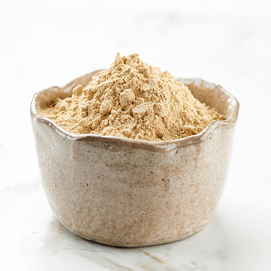 Photographic image depicting a hand-made clay bowl containing finely crushed Maca Root powder