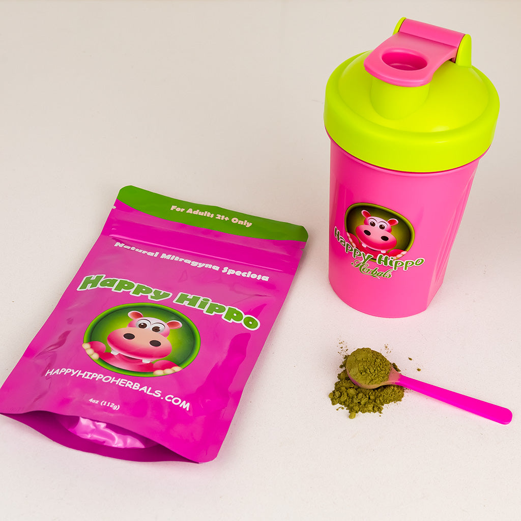 Photographic image depicting a 4oz packet of happy hippo brand kratom powder, and a mixing cup.