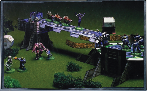 A close up from the box shows a game in progress, including the terrain included with the core set.