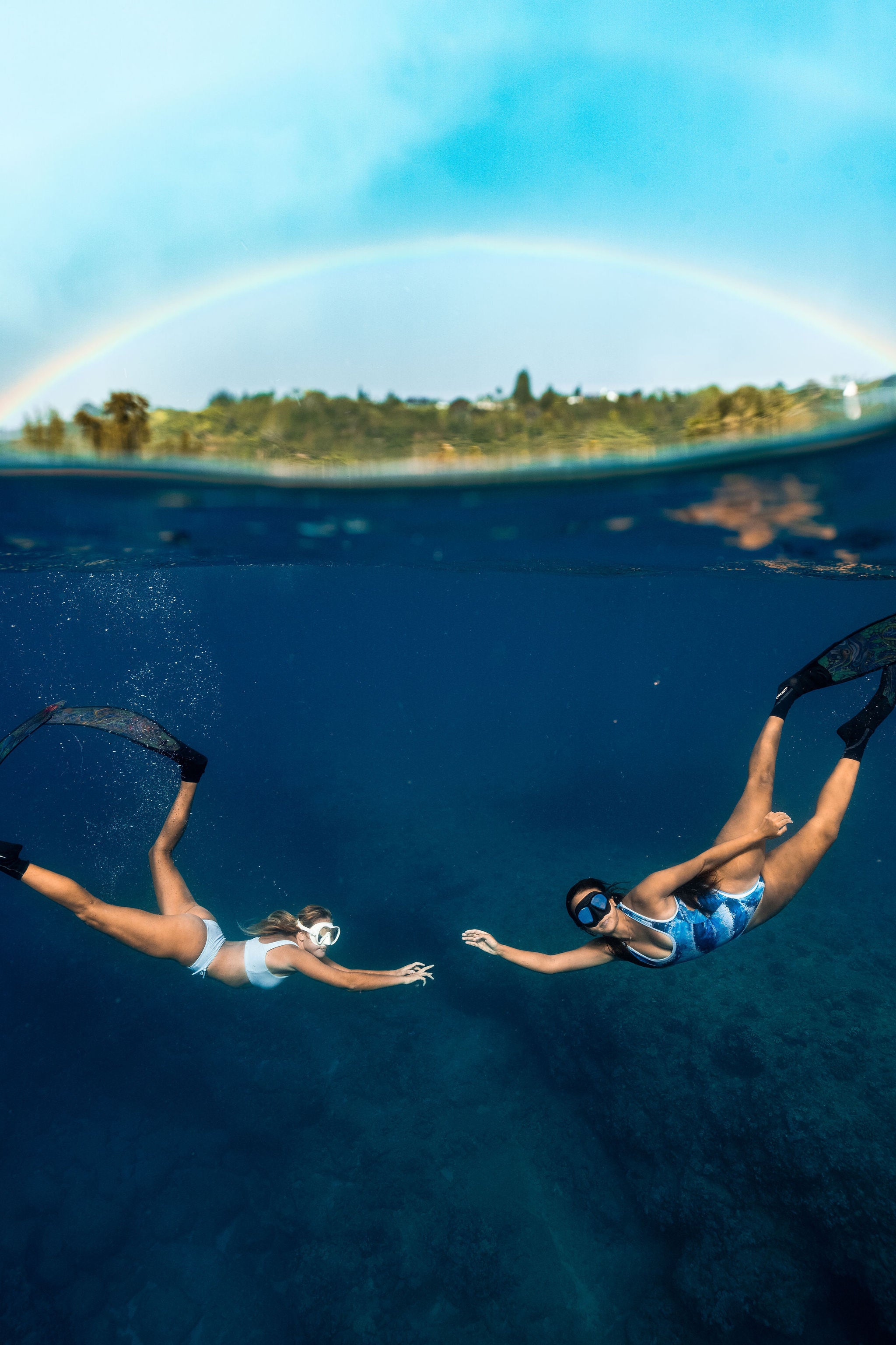 free divers underwater in dkoko bikinis with rainbow