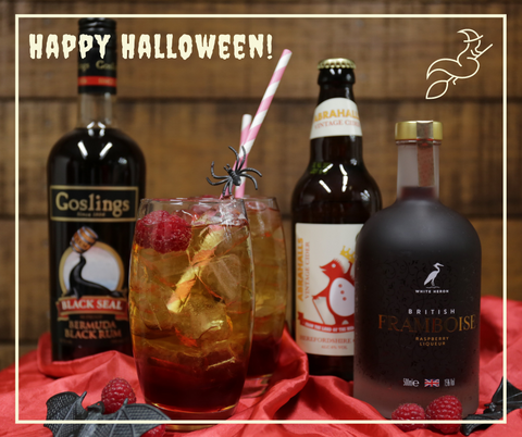 Photo of a bottle of Goslings Rum, Celtic Marches Abrahalls Cider, British Framboise and a cocktail glass showing the different layers of the cocktail with a straw and black plastic spider, All nestled on a red velvet throw.