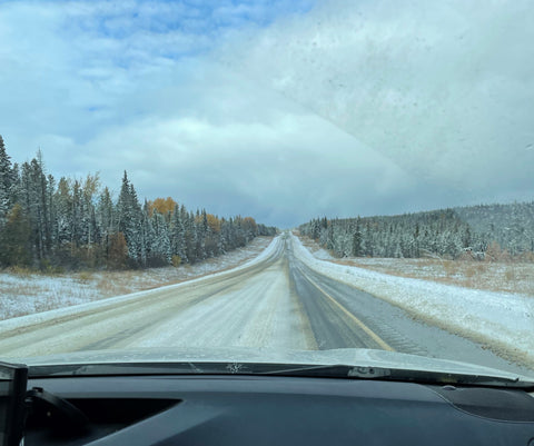 View out car front windshield of snowy highway