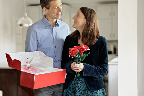 Couple celebrating Wedding Anniversary with a Card and Paper Roses 