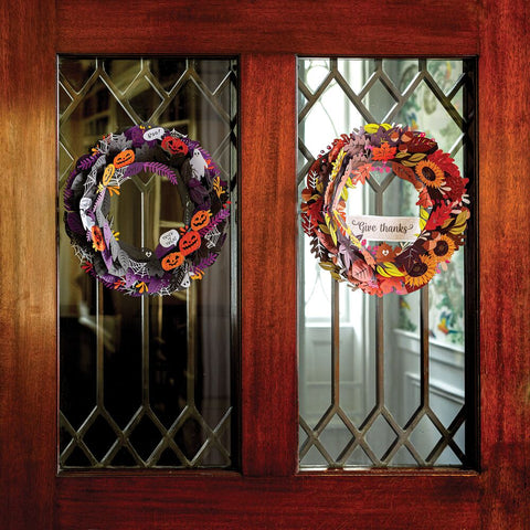 2 Fall themed wreaths hanging on a front door.