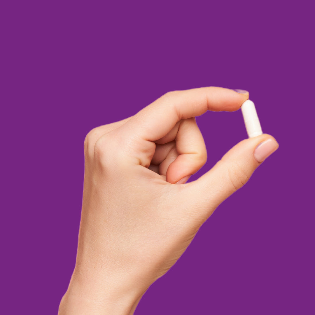 Image of finger and thumb holding a Vitamini Night Time Supplement Capsule.
