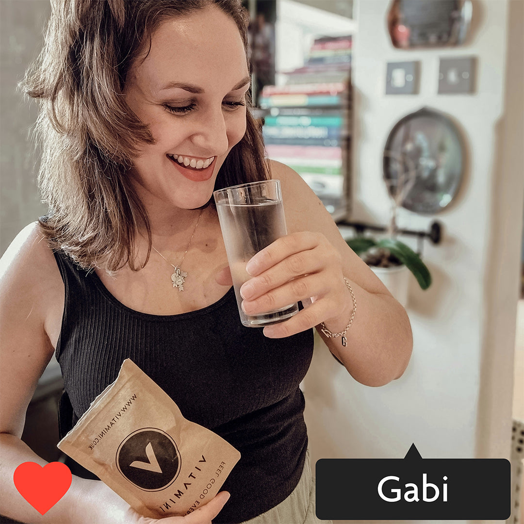 Instagram style image with Gabi tagged in. Gabi is taking her Vitamini Collagen Supplement with a glass of water, she is smiling and holding a Vitamini Advanced Collagen Eco-Pouch.