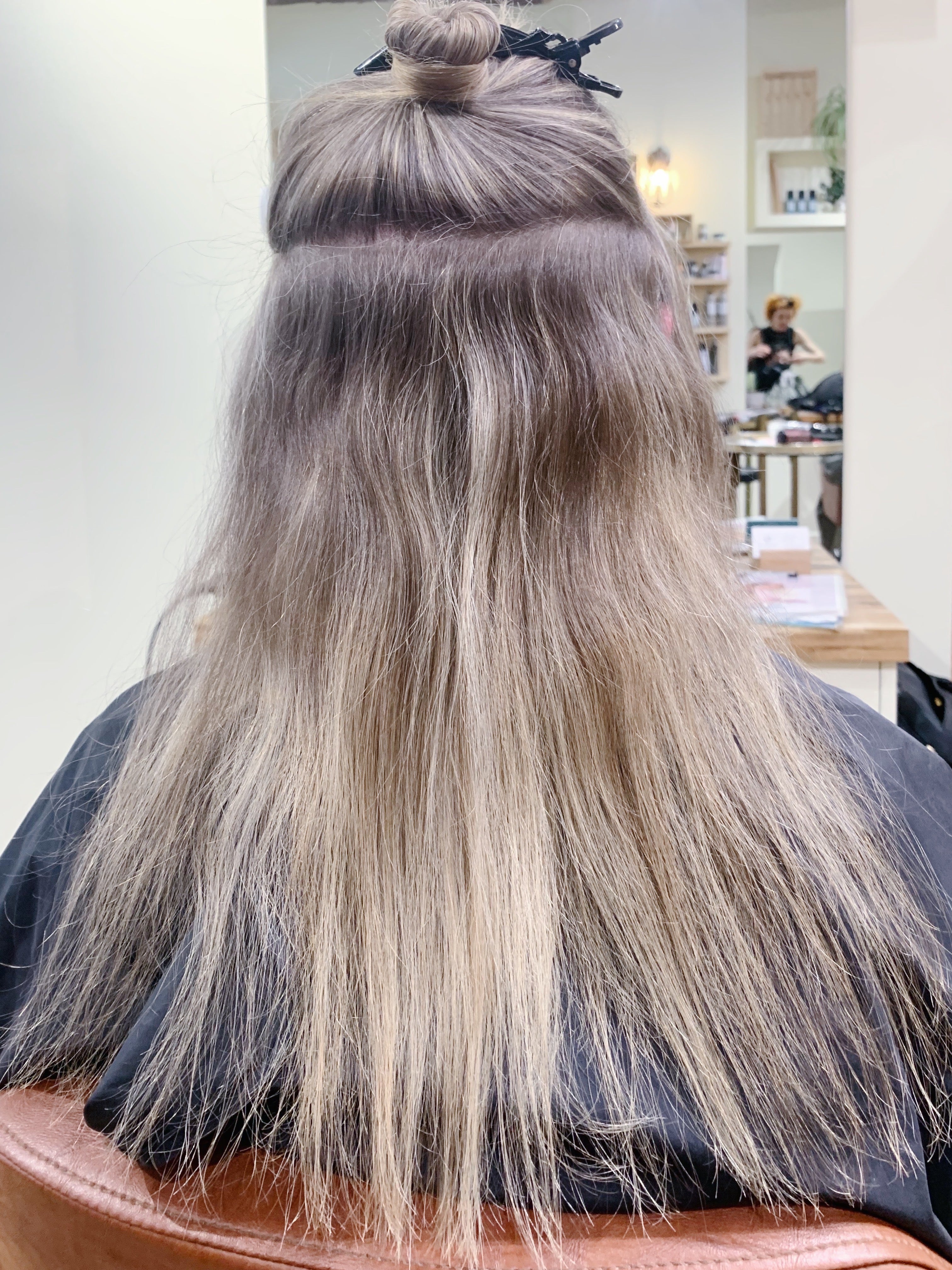 A woman with thin hair getting hair extensions. 