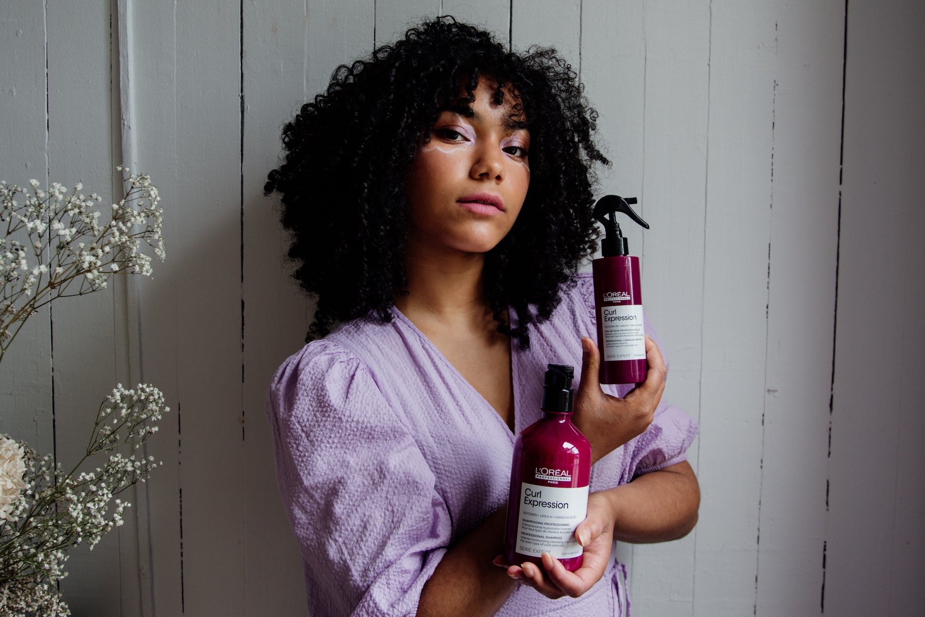 Woman holds products by L'Oreal