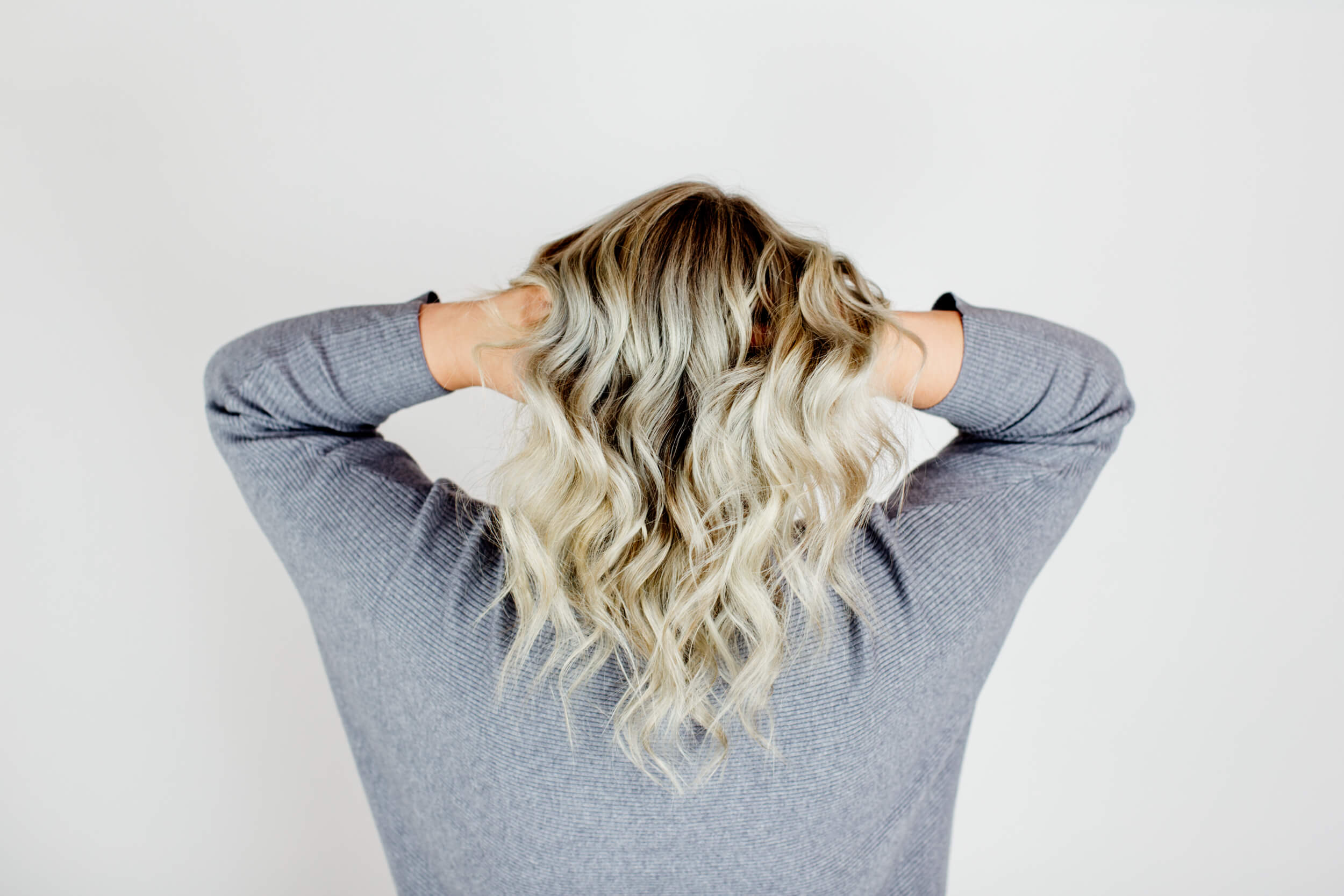 A woman with blonde hair seen from the back.