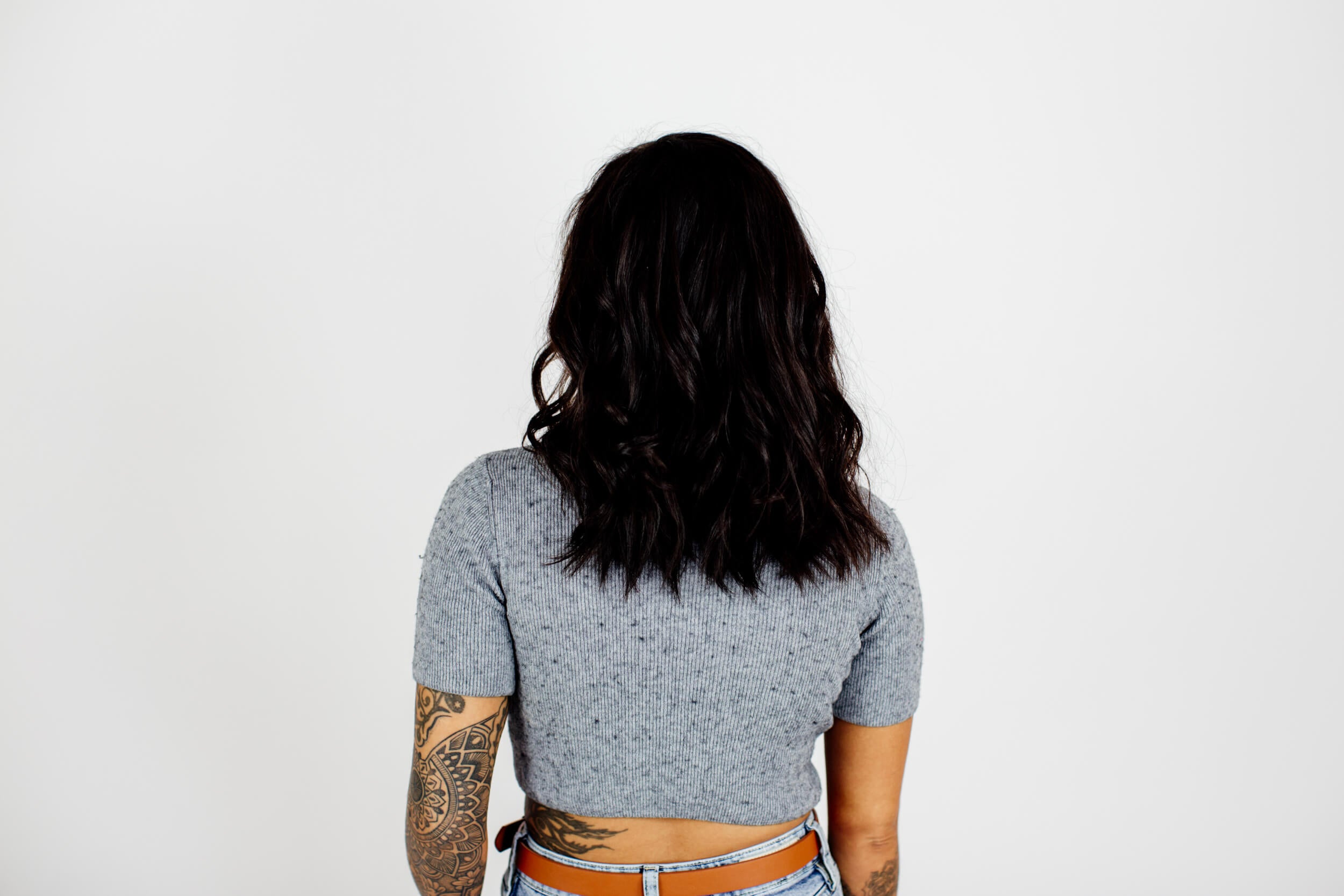 A woman with black permed hair seen from the back.