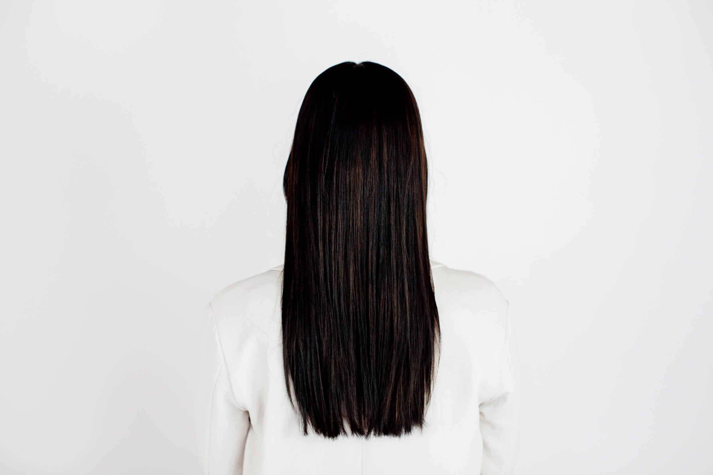 A woman with straight black hair as seen from the back.