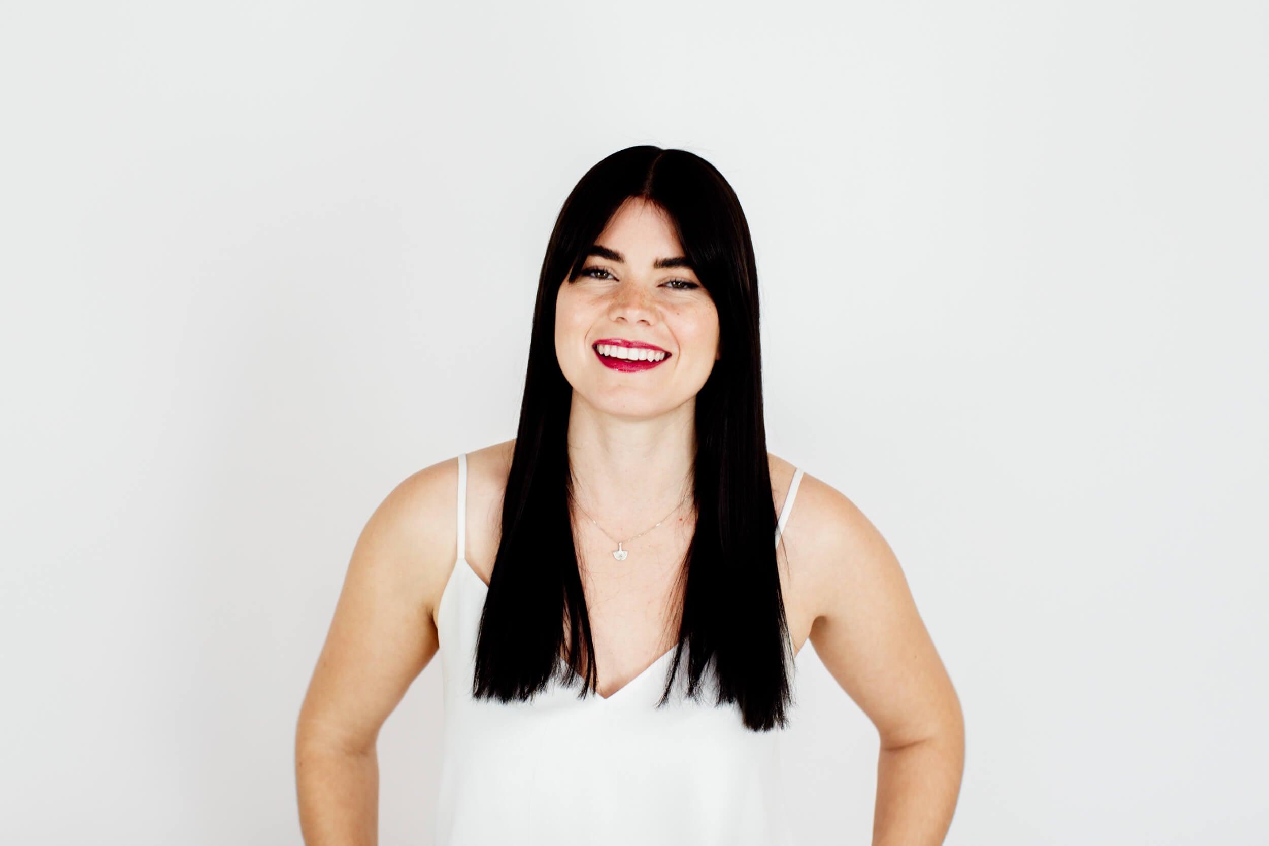 A woman with long black hair smiles at the camera.