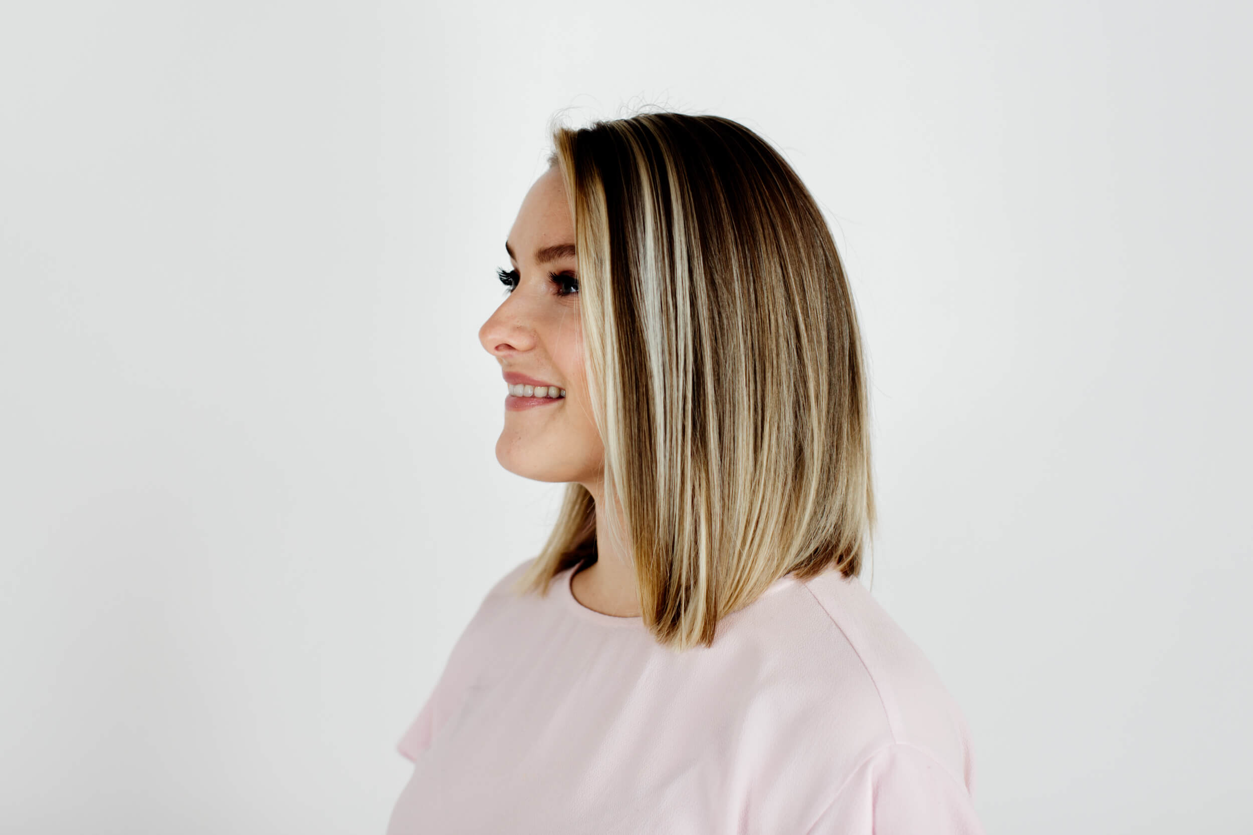 A woman with straight blonde hair poses for the camera.