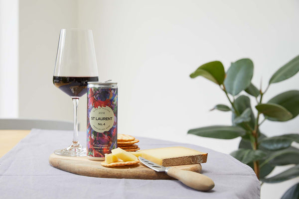 Canned Wine Co. St Laurent next to red wine glass and cheeseboard