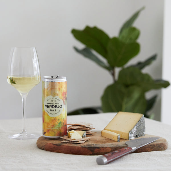 Canned Wine Co. Verdejo next to cheese and a white wine glass