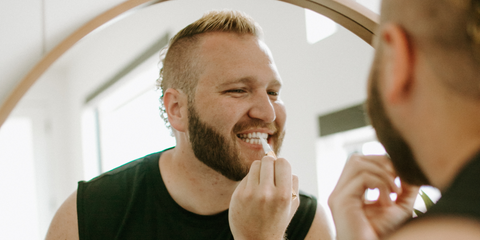 man applying teeth whitening pen