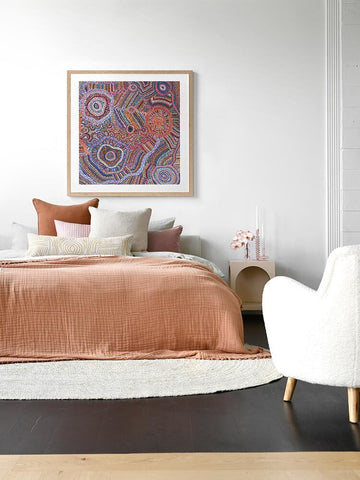 Indigenous framed artwork hanging over a bed