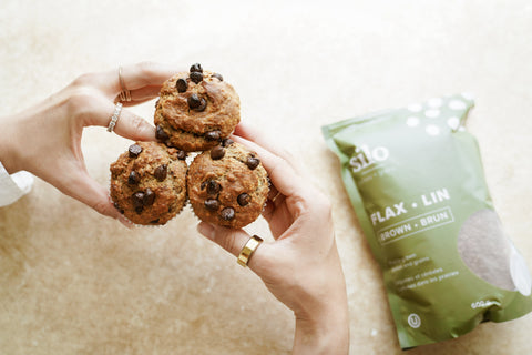 Banana chocolate chip muffins beside a package of Silo Pulses + Grains brown flaxseed