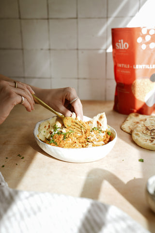 Red lentil curry plated, with Silo Red Lentils in background