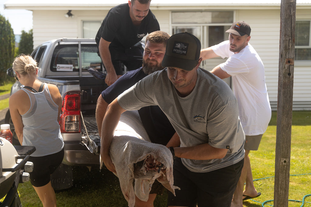 The boys hauling in the marlin to be filleted and smoked. All wearing tees and hats from the Desolve Untouched Waters Summer '23 Collection